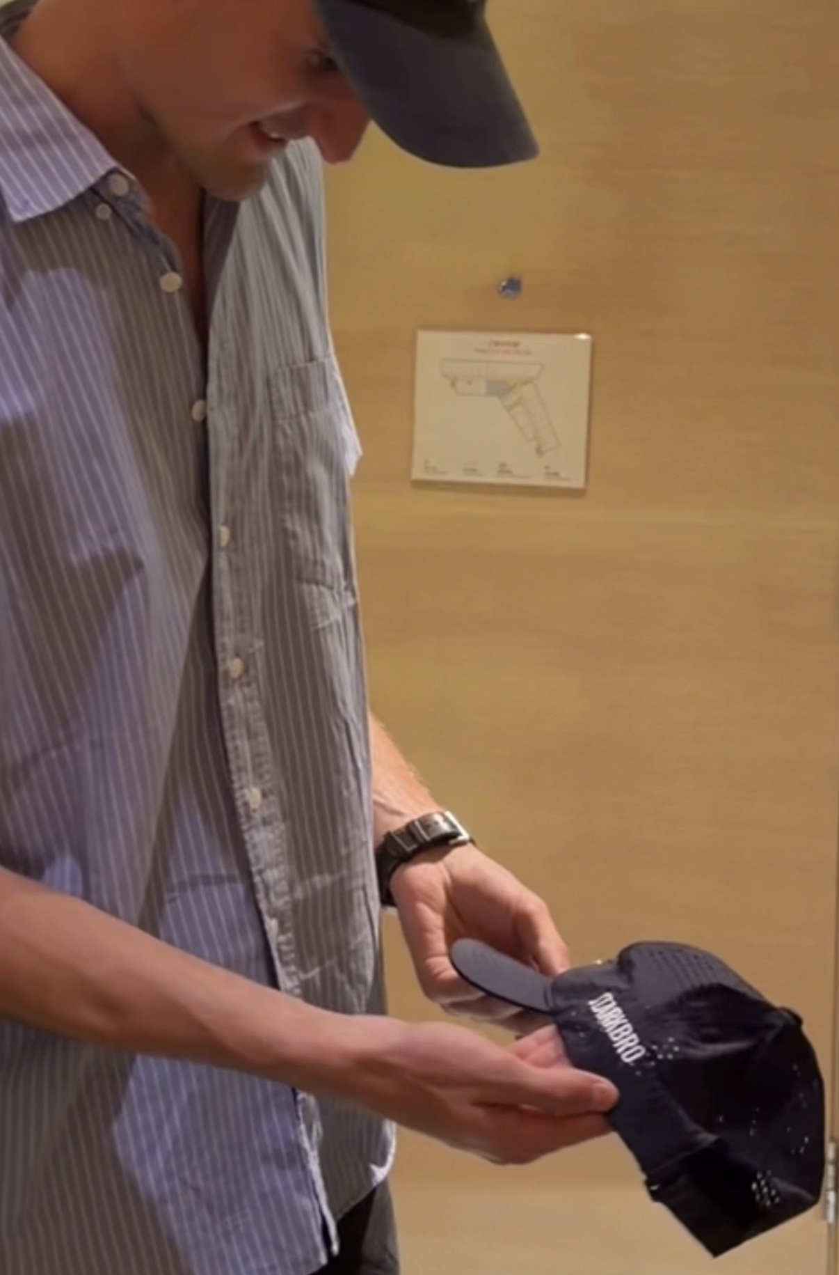 Hands inspecting a navy STARKBRO performance cap