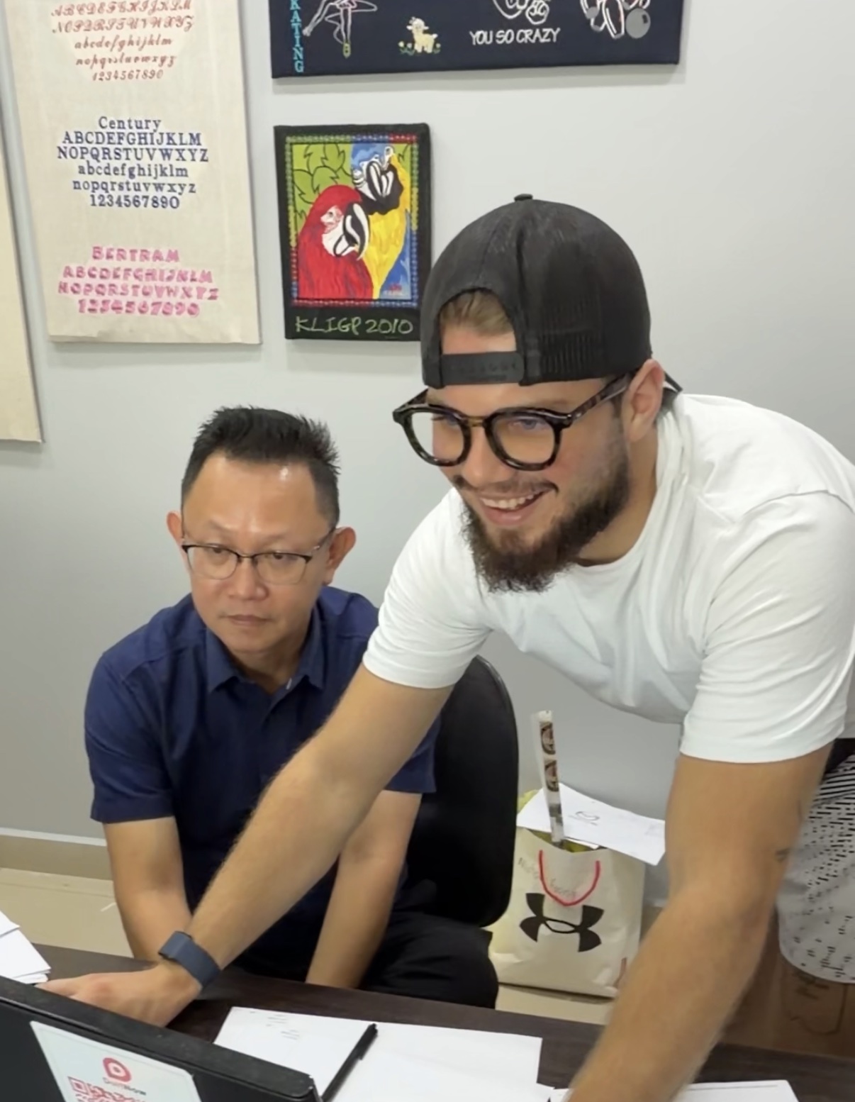 The founder reviewing embroidery designs together with the workshop owner